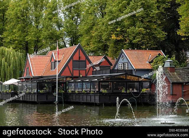 Copenhagen, Denmark A typical Danish restaurant on a pond with flag at Tivoli Gardens