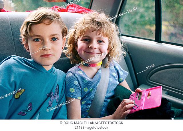 Two sisters as passengers in a car on a family outing