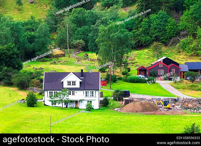 Norwegian houses, village landscape near Flam, Norway. Green hill meadows and trees