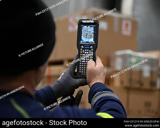 PRODUCTION - 07 December 2023, Hesse, Frankfurt/Main: A DB Schenker Jetcargo employee photographs a pallet with a scanner in the logistics company's air freight...