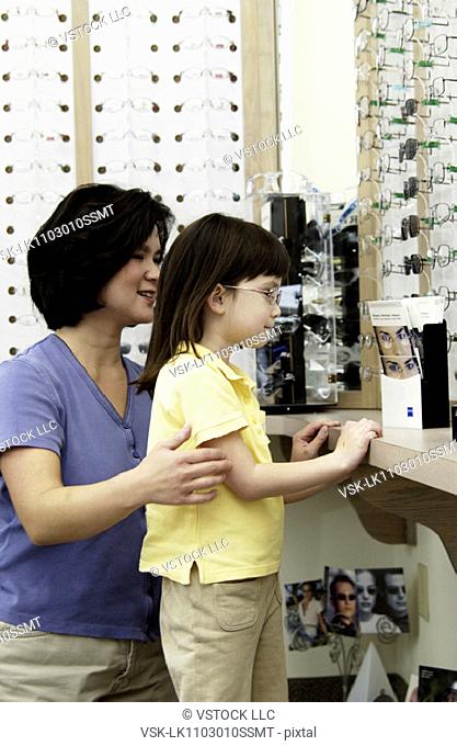 Asian mom and daughter choosing eyeglasses