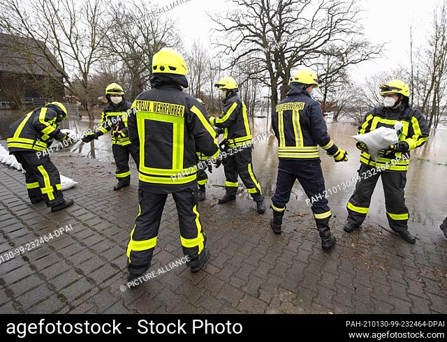 30 January 2021, Hessen, Lindheim: Firefighters pile up sandbags to protect homes against the flooding of the Nidder. In the Wetterau region