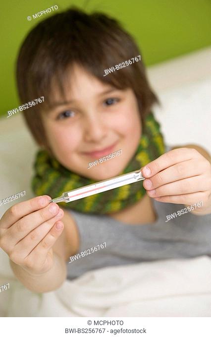 sick boy with clinical thermometer lying in bed