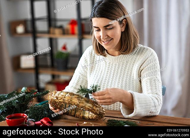 woman making fir christmas wreath at home
