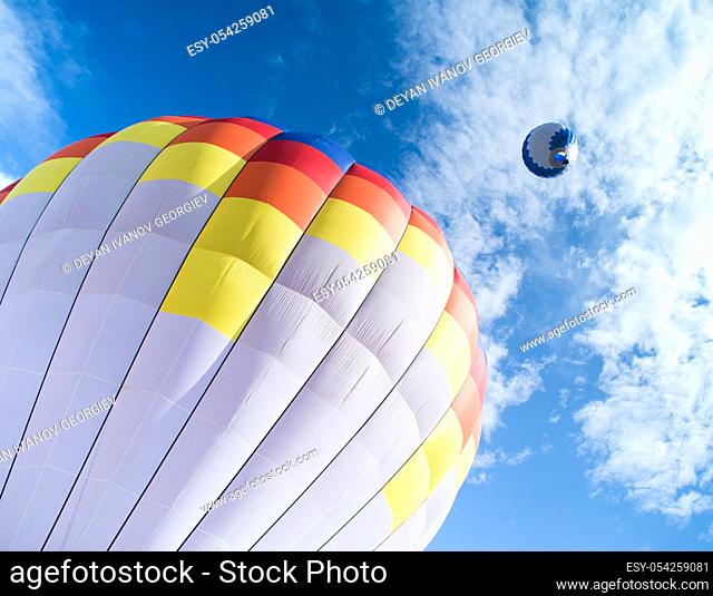 Multicolored Balloon in the blue cloudy sky