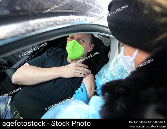 07 April 2021, North Rhine-Westphalia, Schwelm: Andreas Köhler (l) is vaccinated with Astrazeneca's vaccine at the Drive-In Vaccination Center in the...