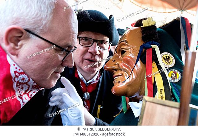 A fool's figure known as 'Schantle' talks to Volker Kauder, CDU/CSU parliamentary group chairman (l), and Rottweil's Mayor Ralf Bross (c) at the traditional...