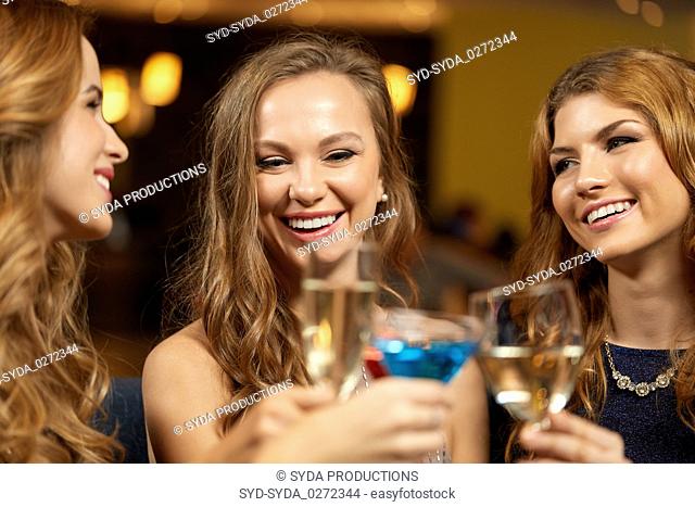 happy women clinking glasses at night club