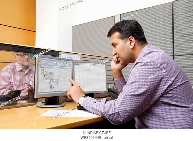 Business executive looking at a graph on a computer monitor