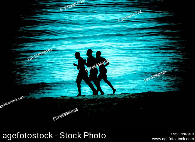 Men running along the beach
