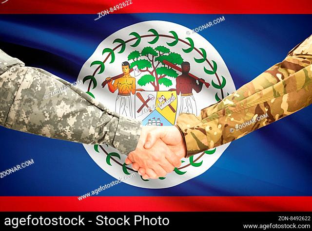 Soldiers shaking hands with flag on background - Belize