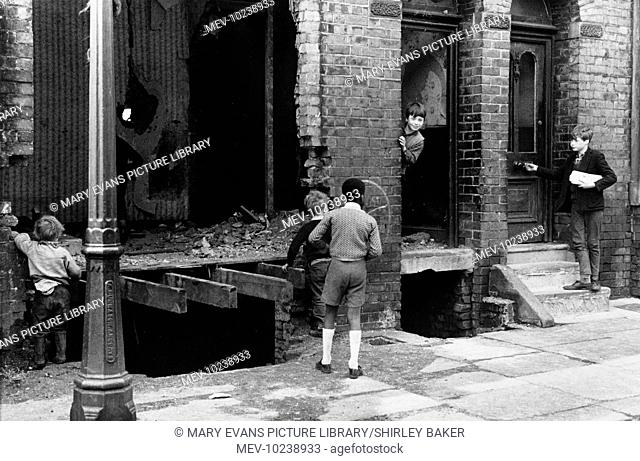 Five young boys play in and around the shell of a derelict terraced house in Manchester. The crumbling brickwork and open cellar voids look like a fun if...