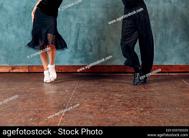 Legs of young couple boy and girl dancing in ballroom dance Jive