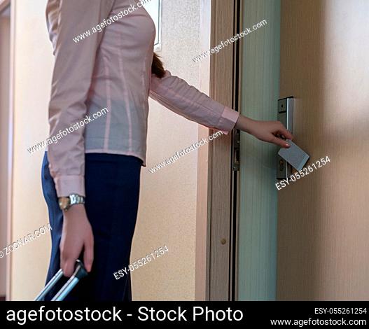 Image of woman opens door to room using electronic key
