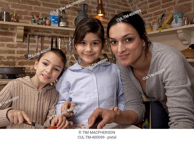 Mother and two daughters 5-8 in kitchen, portrait