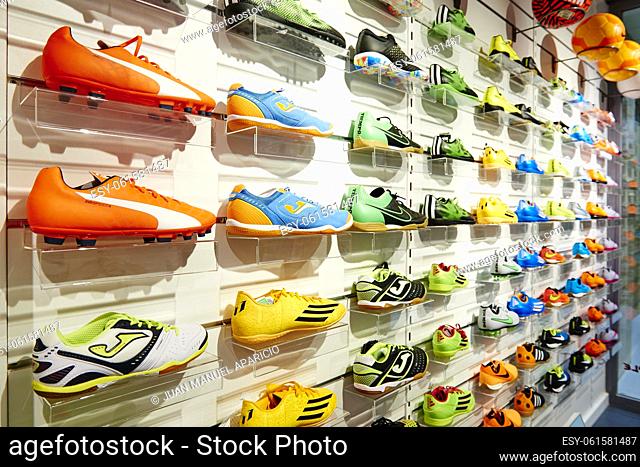 Numerous coloured sneakers in a shoe shop display