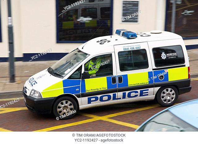 A Police car van driving through the city showing movement in Norwich , Norfolk , England , Great Britain , Uk