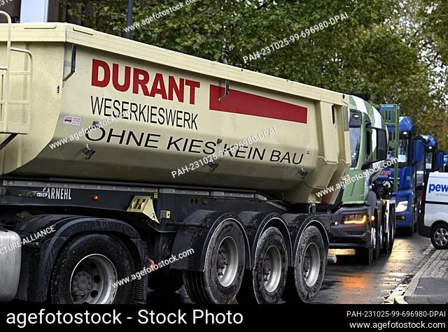 25 October 2023, North Rhine-Westphalia, Duesseldorf: Concrete mixers and gravel trucks, including one from the Durant-Weserkieswerk Höxter with the slogan ""No...