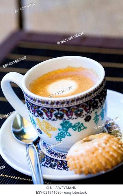 Tasse mit frischem Kaffe Espresso Kaffeelöffel und Feingebäck