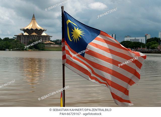 The Malaysia flag is waving in the wind on the shore of the Sarawak River in front of the Sarawak State Legislative Assembly Building in Kuching, Malaysia