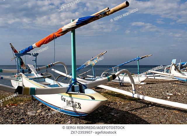 A fisherman with several fishing boats on the beach of Amed, a small fishing village in East Bali. Amed is a long coastal strip of fishing villages in East Bali