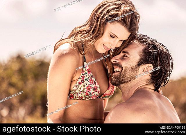 Happy affectionate young couple outdoors in summer