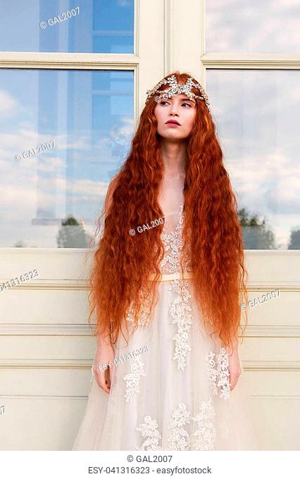 Beautiful red-haired girl with long curly hair in the bride, in a long lace  dress, Stock Photo, Picture And Low Budget Royalty Free Image. Pic.  ESY-041315394 | agefotostock