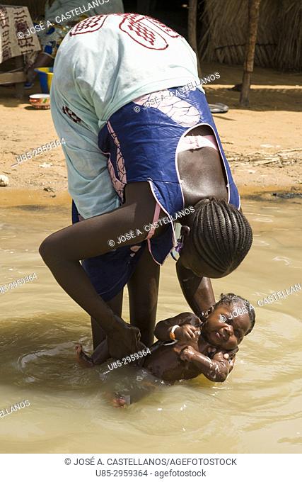 Mother washing her son in river Niger, in a little bozo ethnic group village opposite to Segou City. Mali