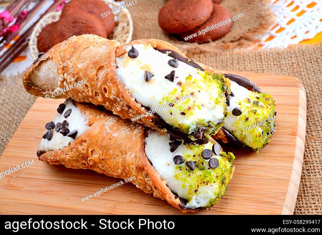 very sweet cannoli siciliani filled by ricotta cheese and sugar with pistachios and chocolate drops