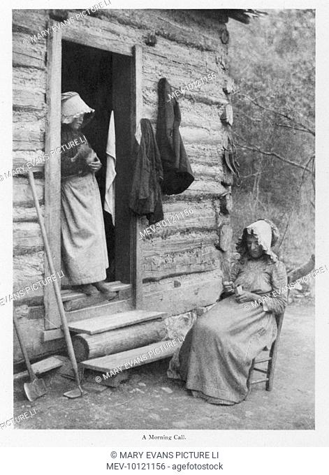 Two mountain women of North Carolina at the doorway of a log cabin