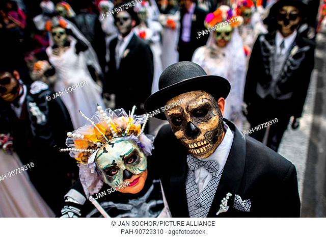 Young couples, costumed as La Catrina, a Mexican pop culture icon representing the Death, walk through the town during the Day of the Dead celebrations in...