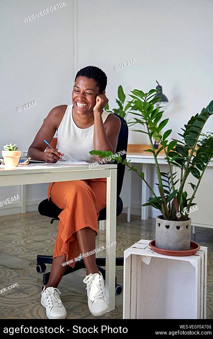 Businesswoman laughing while working at desk