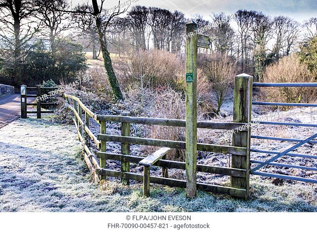 Frost on wooden fence with stile and 'Public Footpath' sign, near Doeford Bridge, Whitewell, Forest of Bowland, Lancashire, England, February