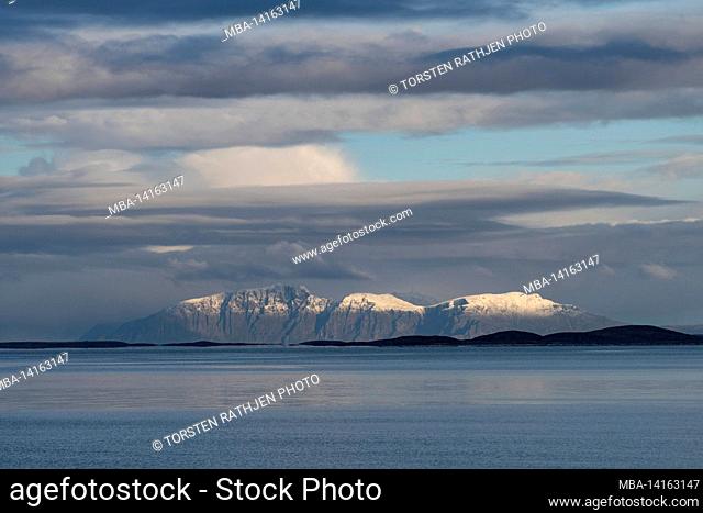 mountain range with snow in the northern sea, holm, nordland, norway