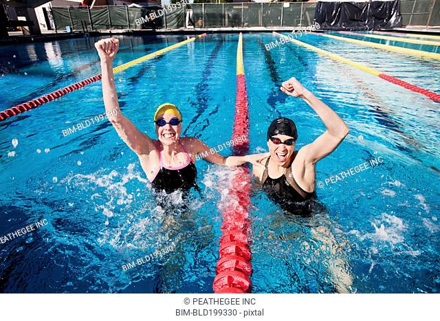 Competitive swimmers cheering in swimming pool