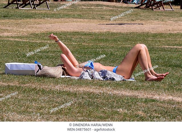 Londoners enjoy on another hot and humid day in the Green Park. Dry and hot weather is likely to continues in Britain for the rest of the week