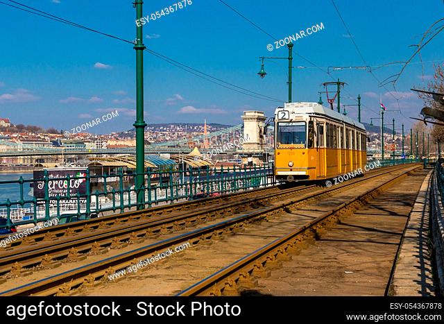 Budapest, Hungary, March 22 2018: Yellow Tram in early winter with cloudy sky. Tram number 2 is famous for being the best european line selected by National...