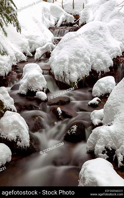 Langzeitbelichtung eines Bachs im verschneiten Bayrischen Wald, Bayern, Deutschland. Long exposure of the Kleine Ohe, a small creek flowing through the snowy...