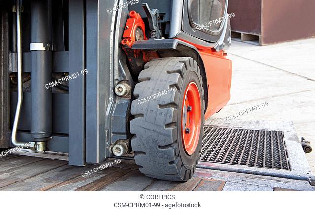 Close up of a forklift on the ramp of a trailer