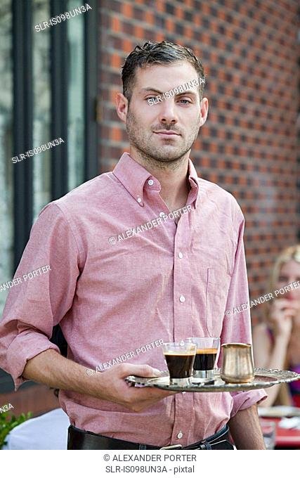 Waiter with espresso coffees
