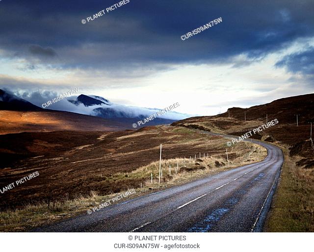 Rural road and misty mountains, Assynt, North West Highlands, Scotland, UK