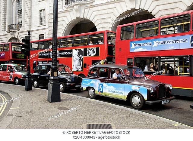 Three traditional London taxi cabs and three red London buses, London, England