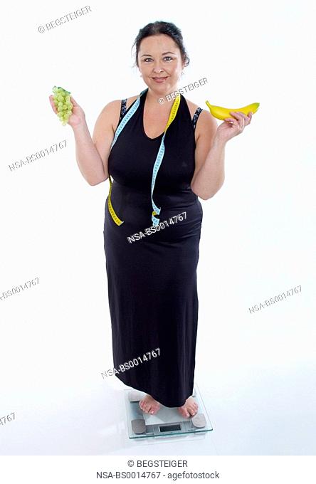 chubby woman with fruits on scale