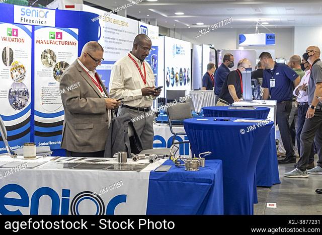 Novi, Michigan - Participants study their cell phone during the Battery Show and the Electric and Hybrid Vehicle Technology Expo