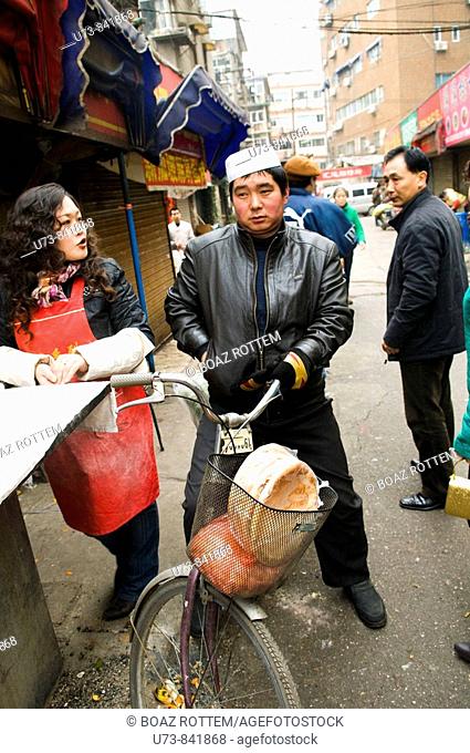 A Muslim man buys fresh bread in a local Xinjiang style bakery in the streets of Nanjing, China