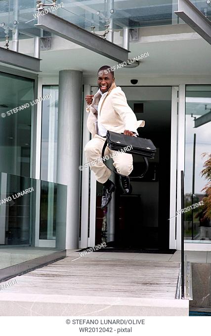 Businessman jumping of happiness outside his office