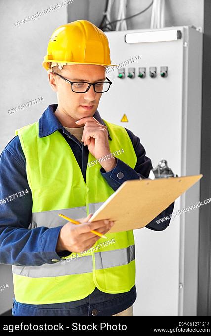 electrician with clipboard at electric board
