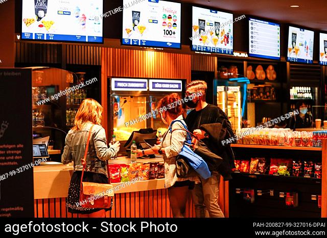 26 August 2020, Berlin: Moviegoers wearing masks stand at the box office in the UCI Luxe Mercedes seat. Photo: Gerald Matzka/dpa-Zentralbild/ZB