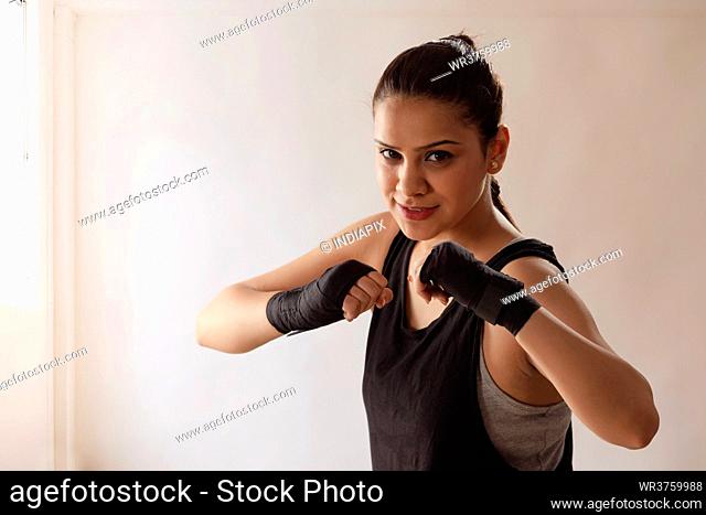 A YOUNG WOMAN WRESTLER LOOKING AT CAMERA WHILE PRACTISING