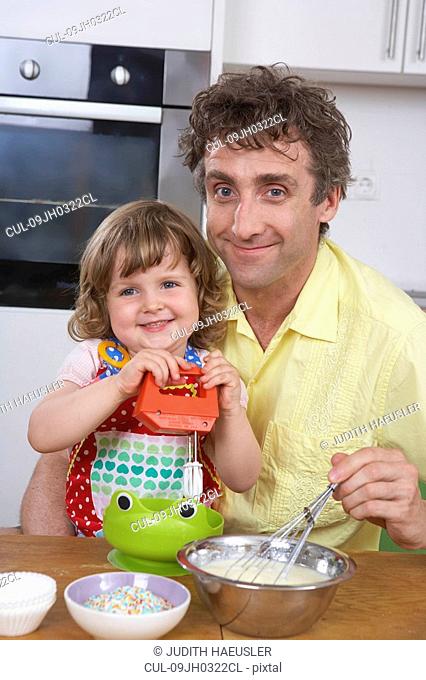 Father and daughter, stirring batter